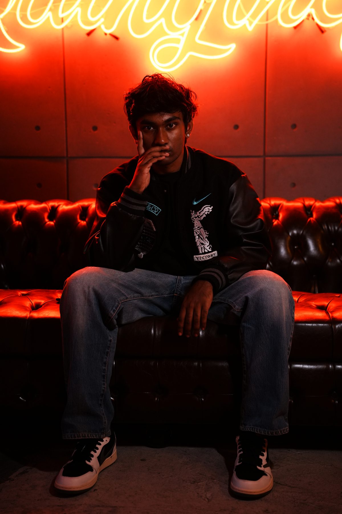 RYKARA seated under red neon, press portrait 10